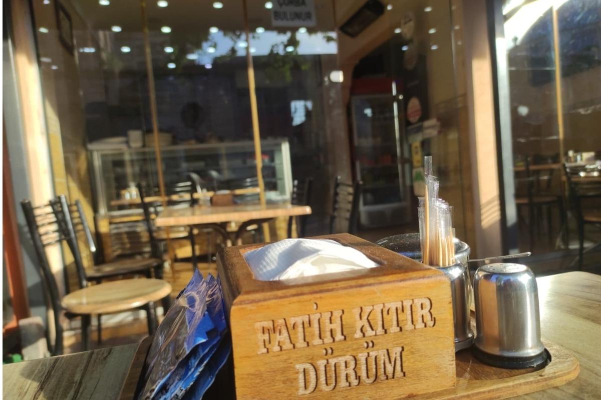 Fatih Kıtır Dürüm restoranının dış mekanı. Geceleri ışıklandırılmış ağaçlar ve bitkilerle çevrili, açık havada yemek yeme alanı.